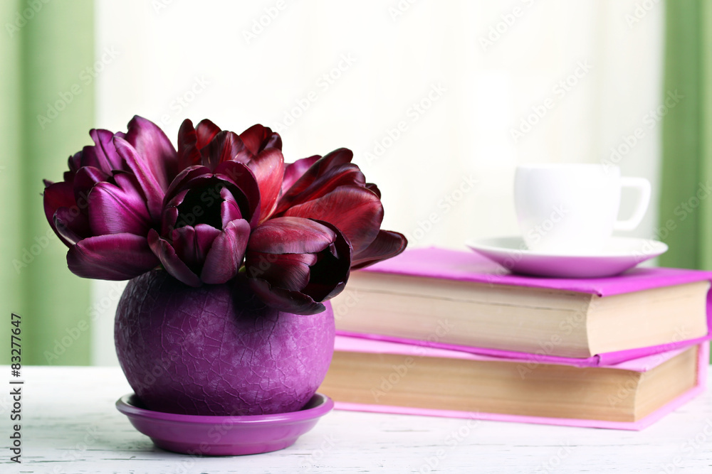 Beautiful tulips in pot with books on fabric background Beautiful tulips in pot with books on fabric background