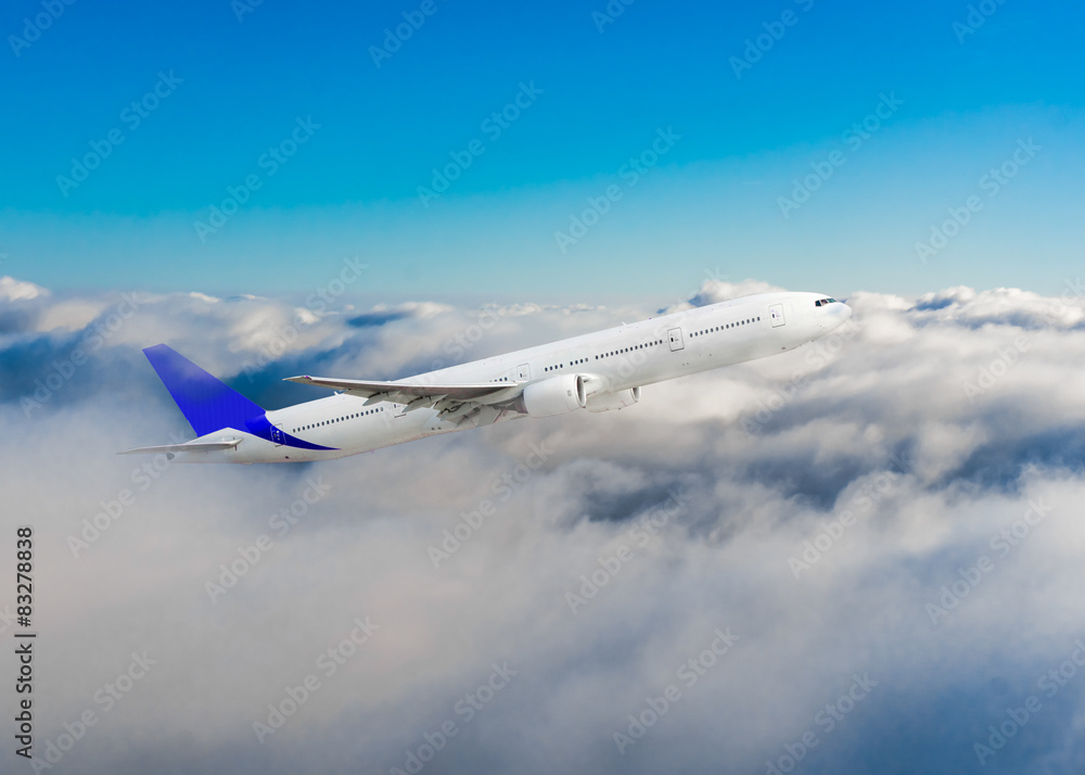 Fototapeta premium Passenger airplane flying above dramatic clouds