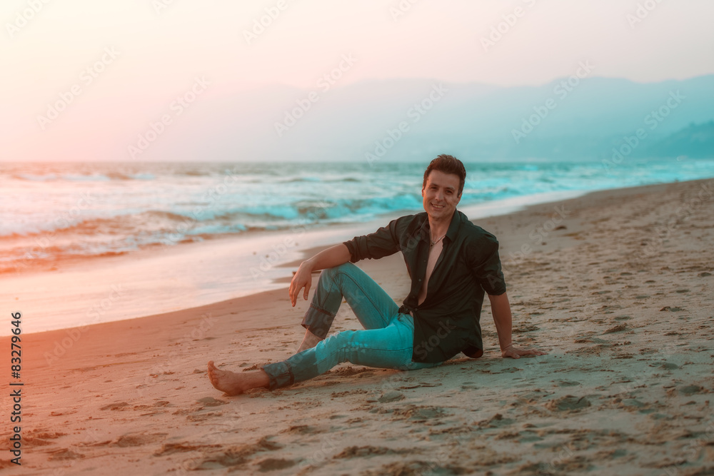 Handsome sexy and smiling man relaxing at beach.