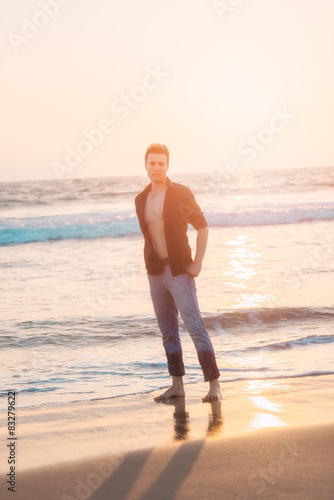 Stylish sexy and serious man standing at beach.