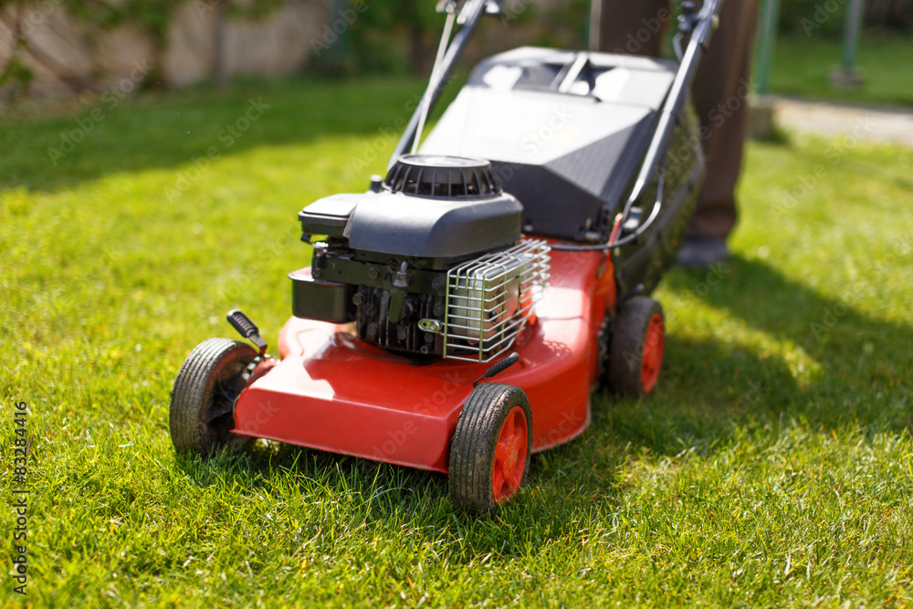 Pensioner mowing lawn with machine Pensioner mowing lawn with machine