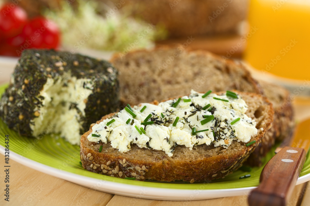 Slice of wholegrain bread spread with goat cheese with herbs Slice of wholegrain bread spread with goat cheese with herbs