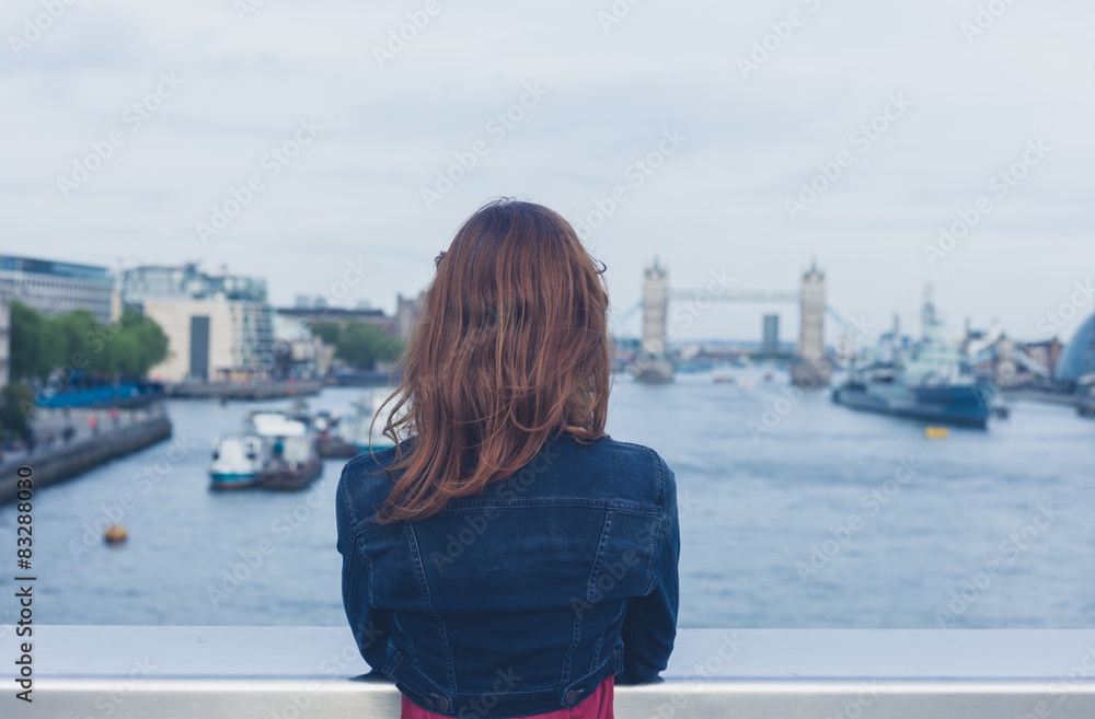 Young woman standing on a bridge and looking at city