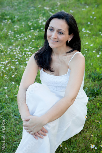 Woman sitting on a flowered meadow