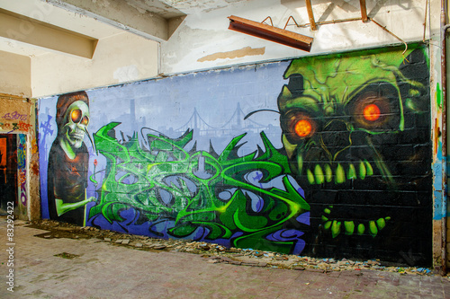 skull monster graffiti in an abandoned factory building