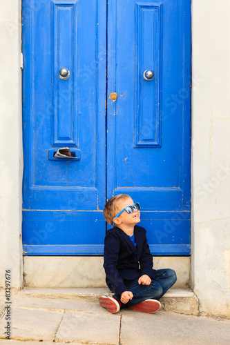 cute little boy outdoors against blue door