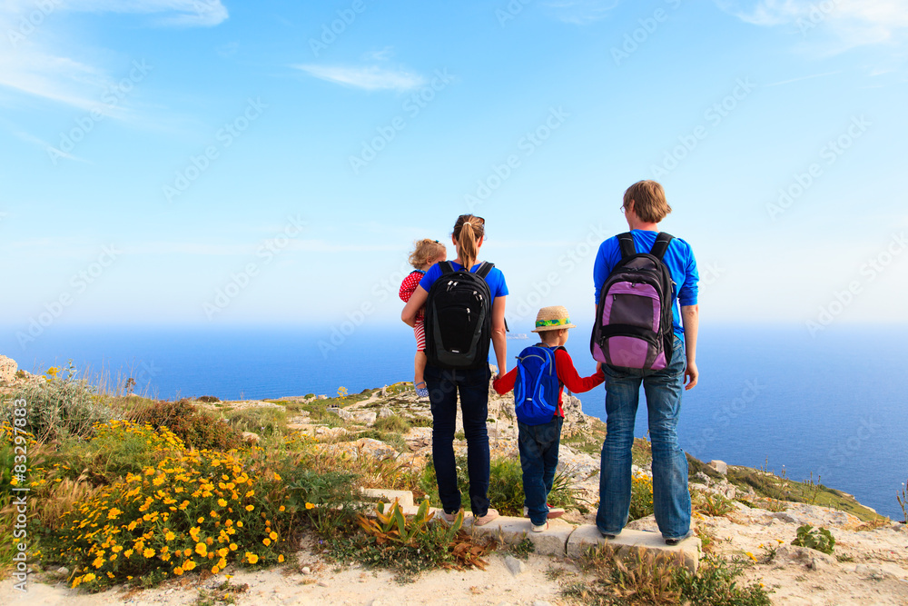 family with kids hiking in summer mountains