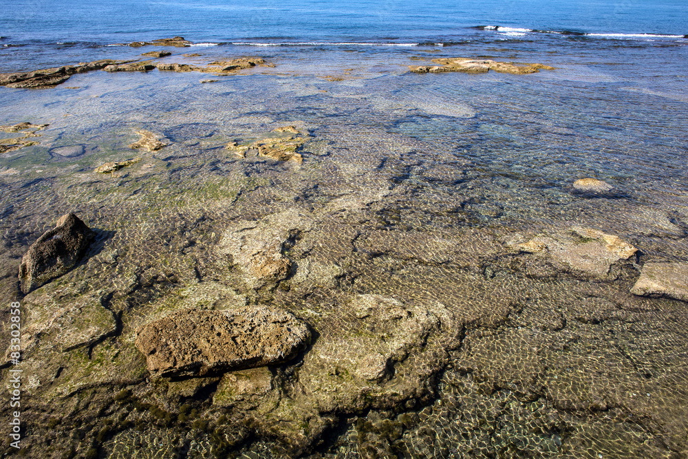 surfacing rocks into blue transparent sea