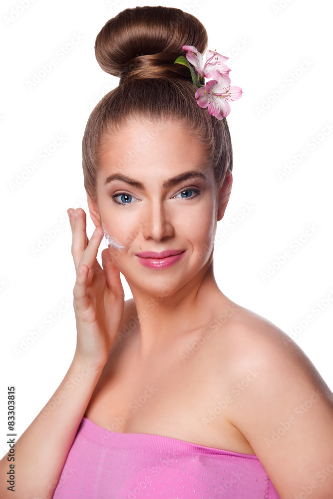 Beautiful young woman putting face cream on isolated on white Beautiful young woman putting face cream on isolated on white