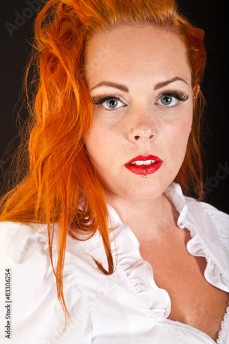 Red hair girl in pin-up style portrait shot in studio