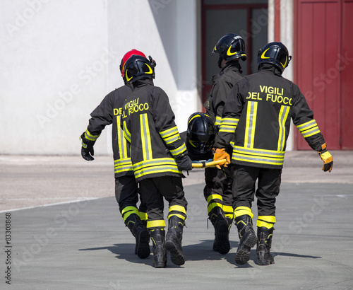 Four brave Firefighters carry a fellow firefighter