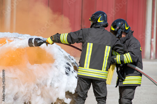 two firefighters in action with foam photo