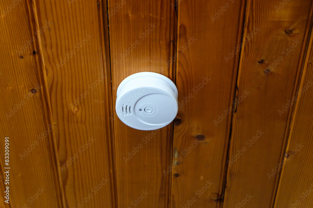 Smoke detector on wood ceiling inside the house Smoke detector on wood ceiling inside the house