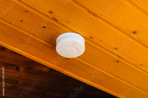 Smoke detector on wood ceiling inside the house