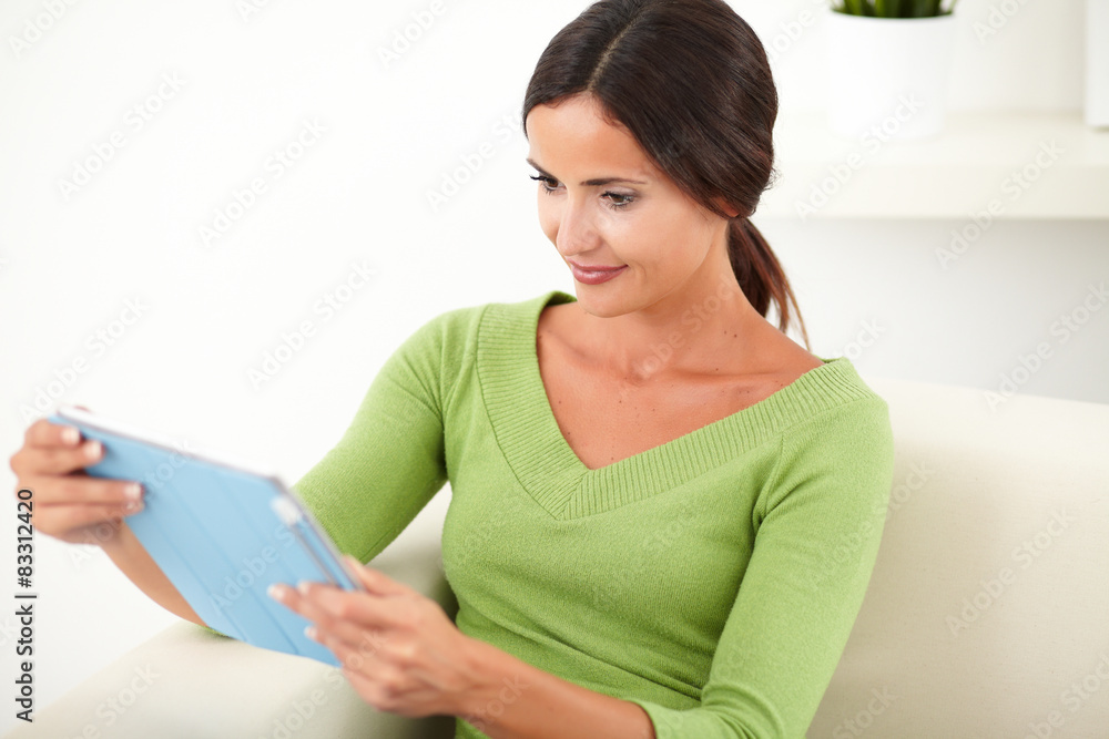 Relaxed lady looking at a tablet Relaxed lady looking at a tablet