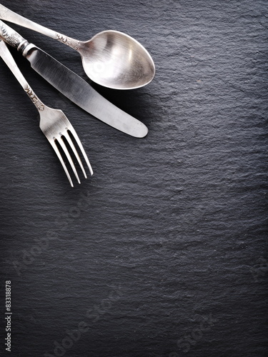 Silver cutlery on a dark grey background. photo