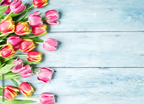 Fototapeta Naklejka Na Ścianę i Meble -  Pink and red tulips on a wooden background.