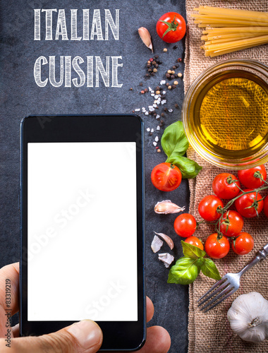 Italian cuisine concept with food and blank screen on cell phone