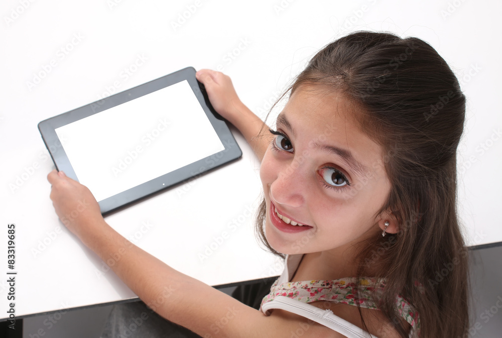 Beaitiful pre-teen girl using a tablet computer. High angle. Beaitiful pre-teen girl using a tablet computer. High angle.