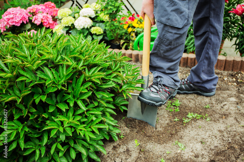 ein junger Mann arbeitet im Garten