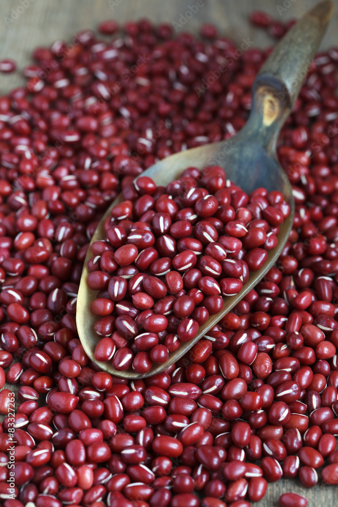 Dry red adzuki beans on wooden table, selective focus - some bea Dry red adzuki beans on wooden table, selective focus - some bea