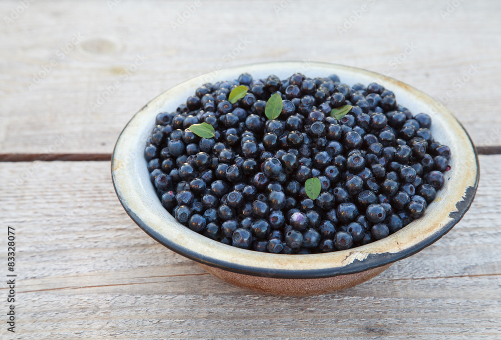 Ripe wild blueberries in a old bowl on the table, closeup Ripe wild blueberries in a old bowl on the table, closeup