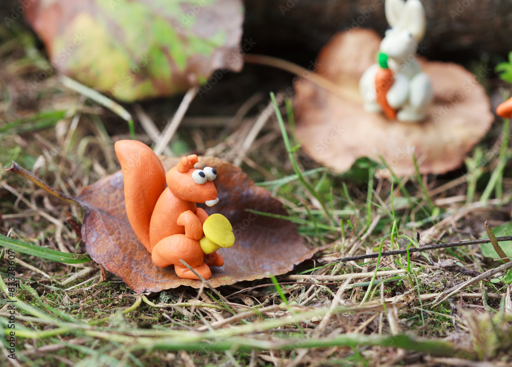 Plasticine world - small homemade squirrel holds the chanterelle Plasticine world - small homemade squirrel holds the chanterelle