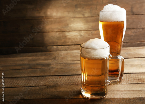 Glasses of beer on wooden background