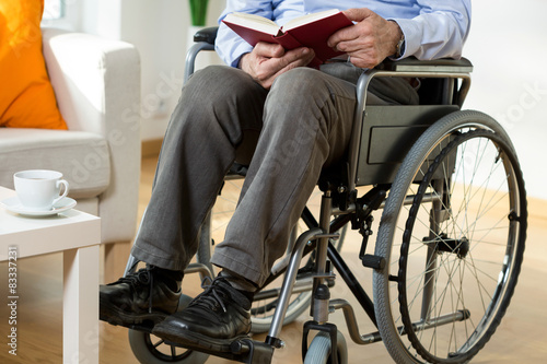 Man on wheelchair reading a book