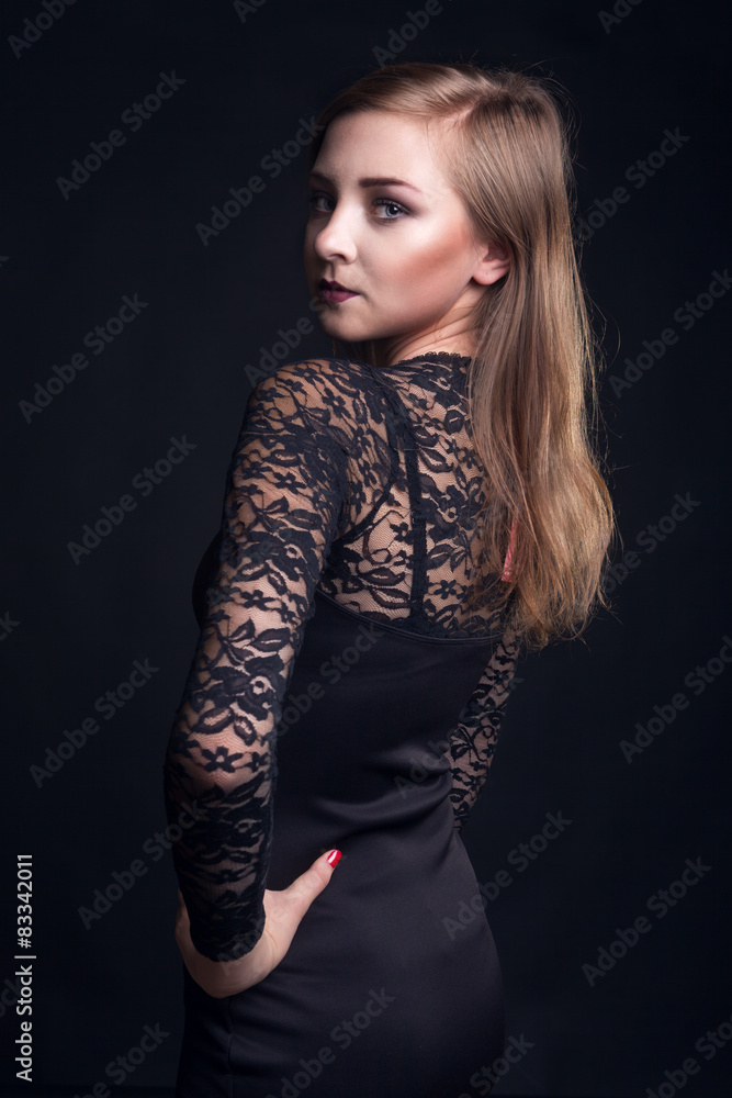 Fototapeta premium Woman in cocktail dress on black background