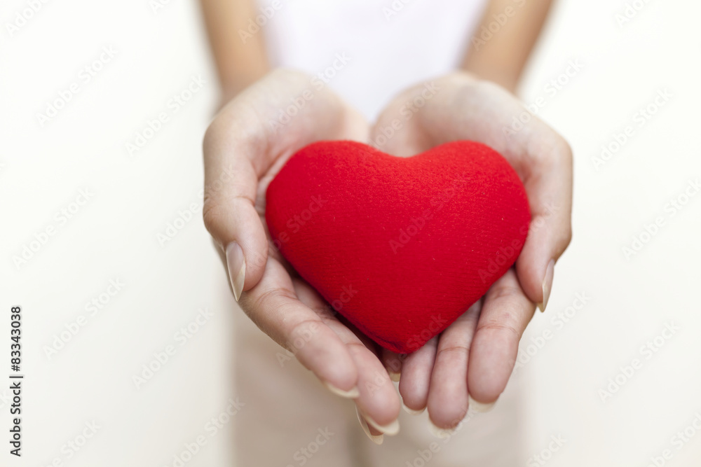 Girl's hand holding red heart with space on background