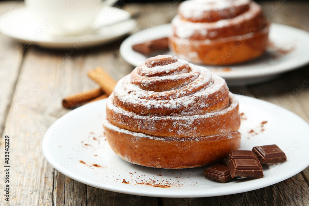 Cinnamon buns on plate on grey wooden background Cinnamon buns on plate on grey wooden background