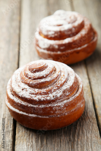 Cinnamon buns on grey wooden background