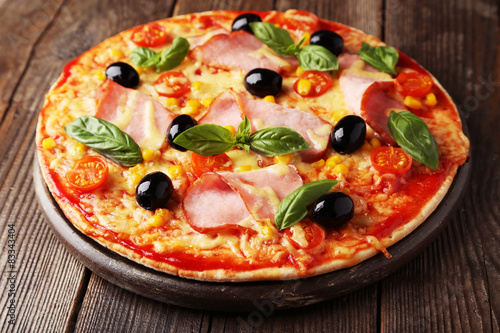 Delicious fresh pizza on brown wooden background