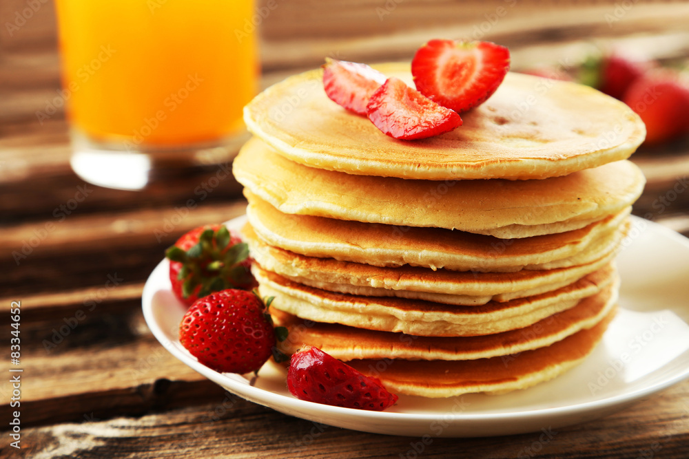 Delicious pancakes with strawberry on brown wooden background Delicious pancakes with strawberry on brown wooden background