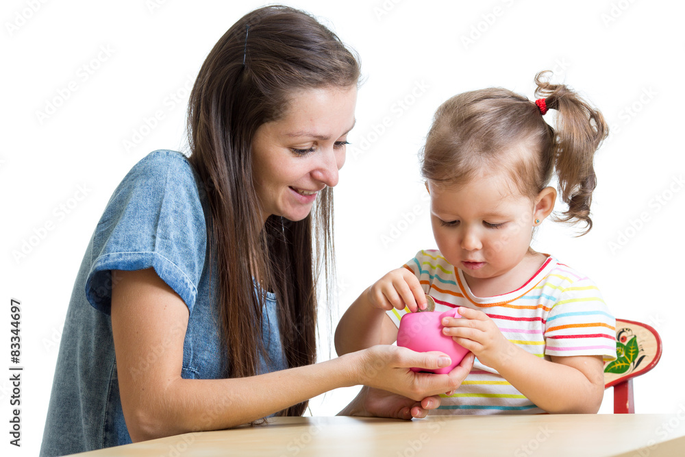 Mother and daughter put coins into piggy bank Mother and daughter put coins into piggy bank