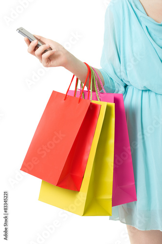 Woman hand holding shopping bags and smartphone on white, clipping path