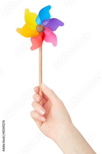 Woman hand holding colorful pinwheel on white, clipping path