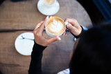 Female hands holding cup with coffee