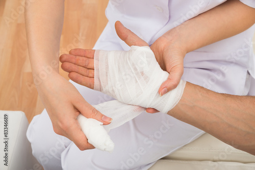 Female Doctor Bandaging Patient s Hand
