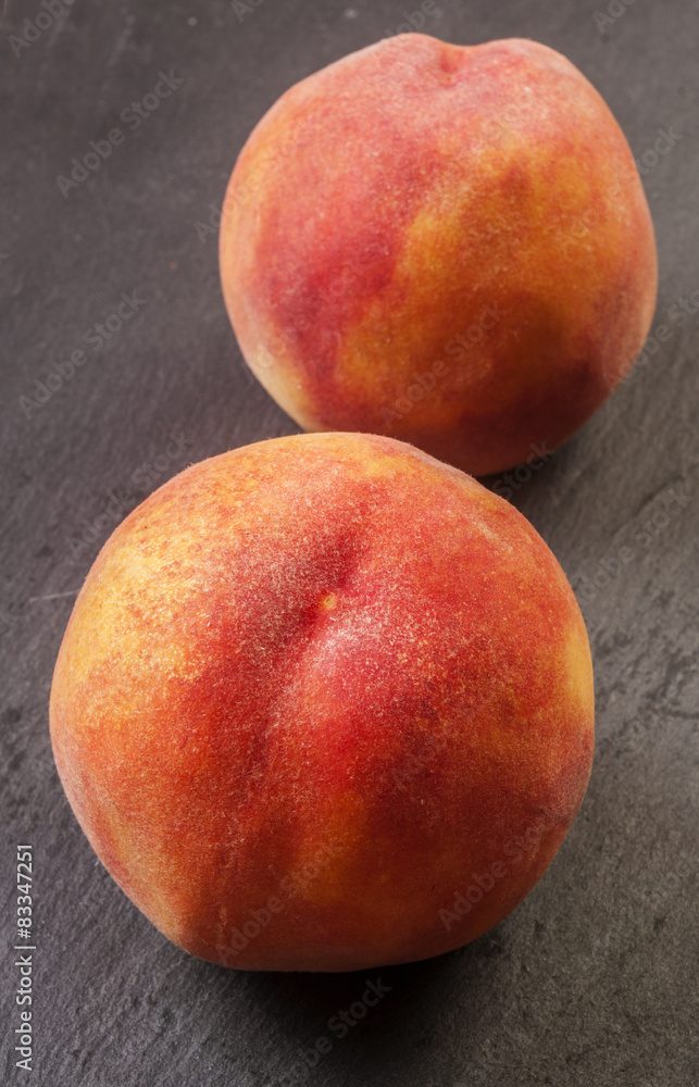 Close up shot of a fresh peach isolated on a black background Close up shot of a fresh peach isolated on a black background