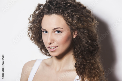 Studio portrait of a seductive girl with curly hair