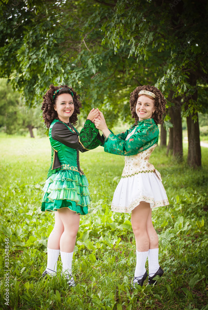 Fototapeta premium Two young beautiful girl in irish dance dress posing outdoor