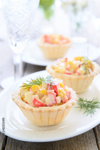 Mini tarts with crab meat and sweet corn salad on festive table
