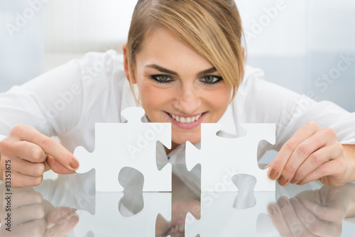 Businesswoman Holding Pieces Of Jigsaw Puzzle