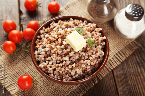 Buckwheat in bowl on brown wooden background