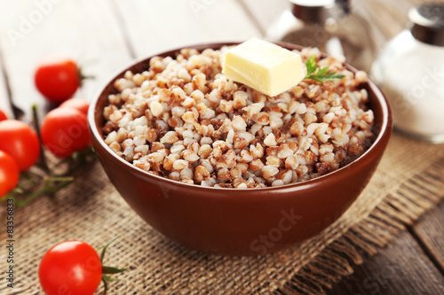 Buckwheat in bowl on brown wooden background