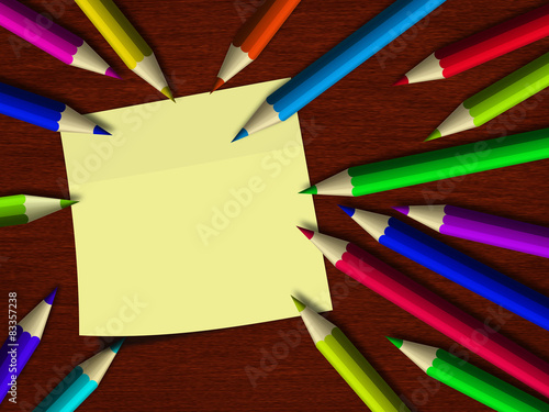 colour pencils lying on wooden desk with note