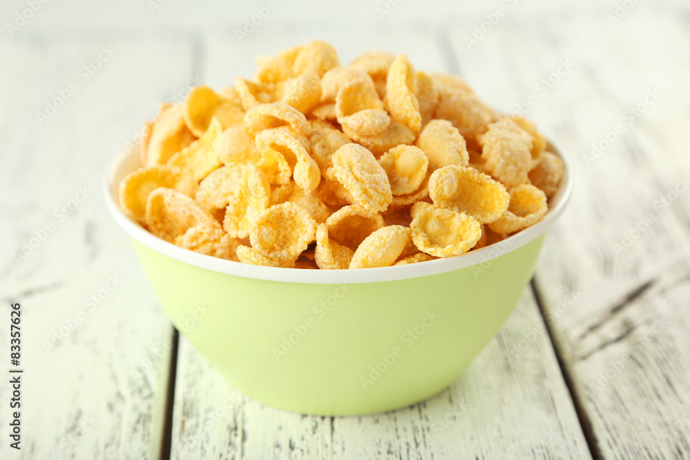 Bowl of cornflakes on white wooden background Bowl of cornflakes on white wooden background