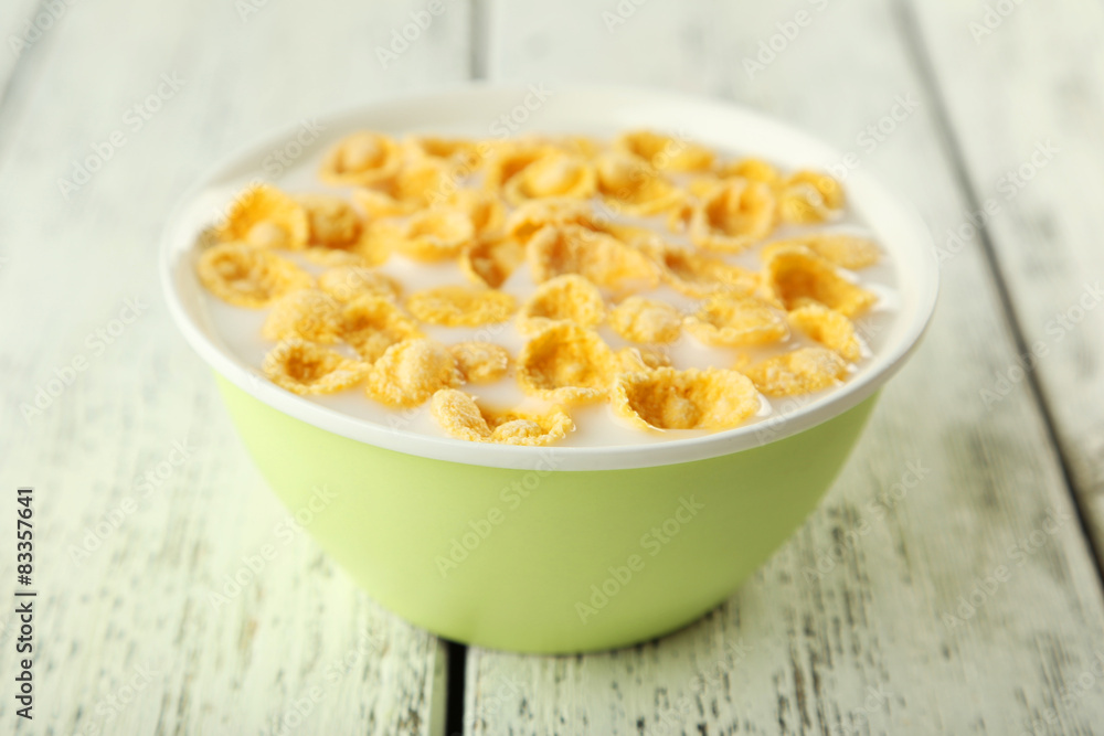 Bowl of cornflakes with milk on white wooden background Bowl of cornflakes with milk on white wooden background
